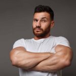 Man in white t-shirt with large muscles.