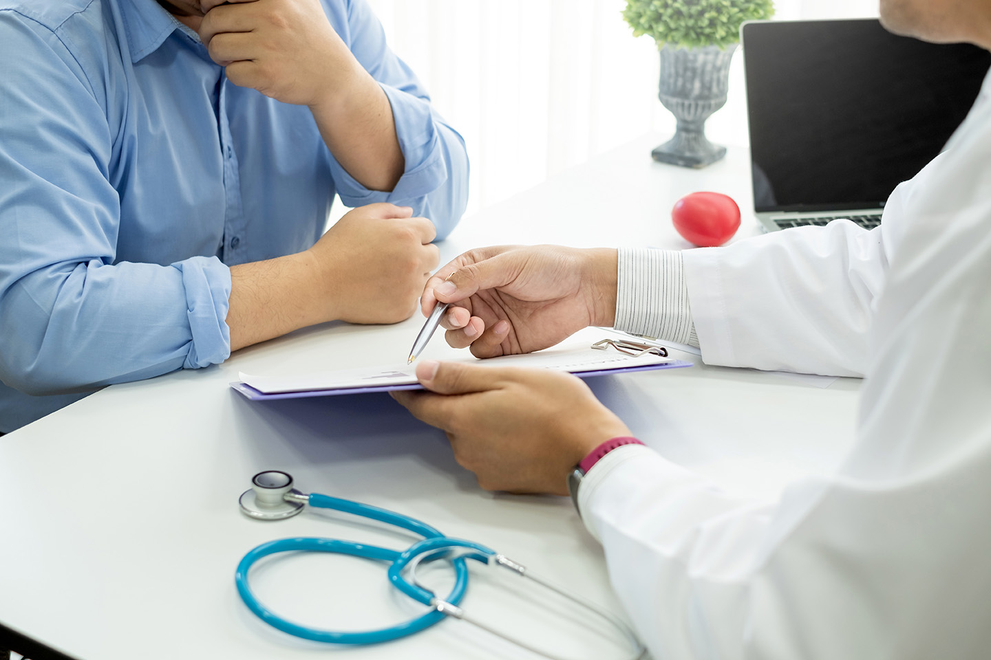 Close-up of doctor showing his patient information on a clipboard