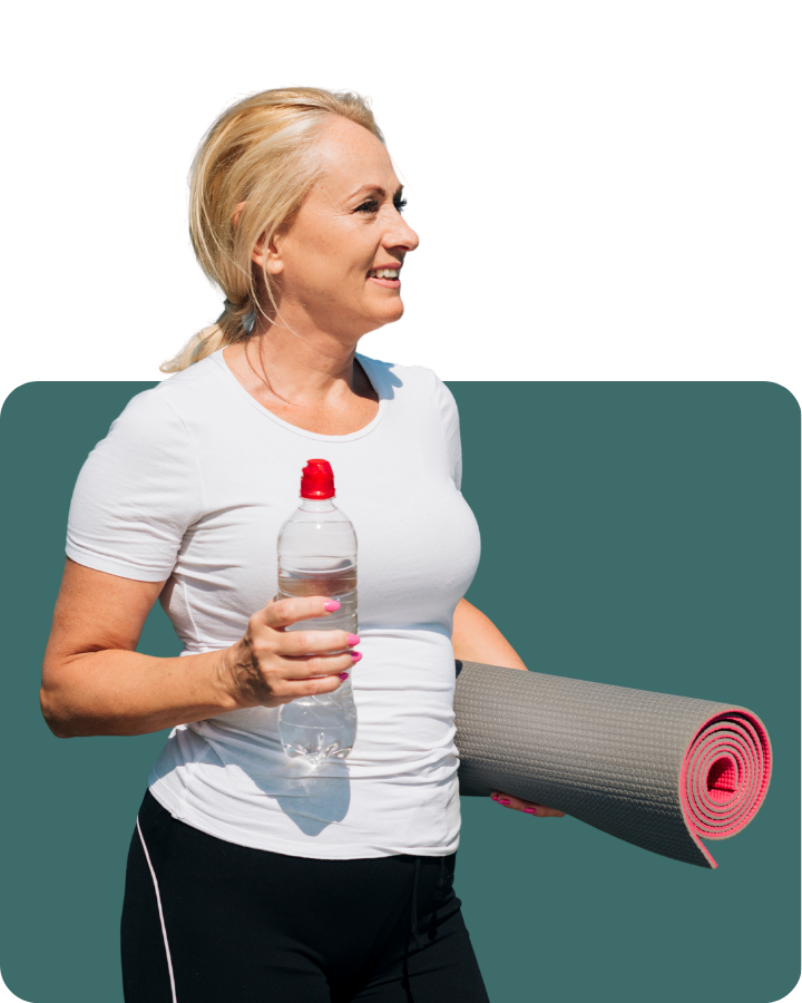 Woman holding a yoga mat and water bottle